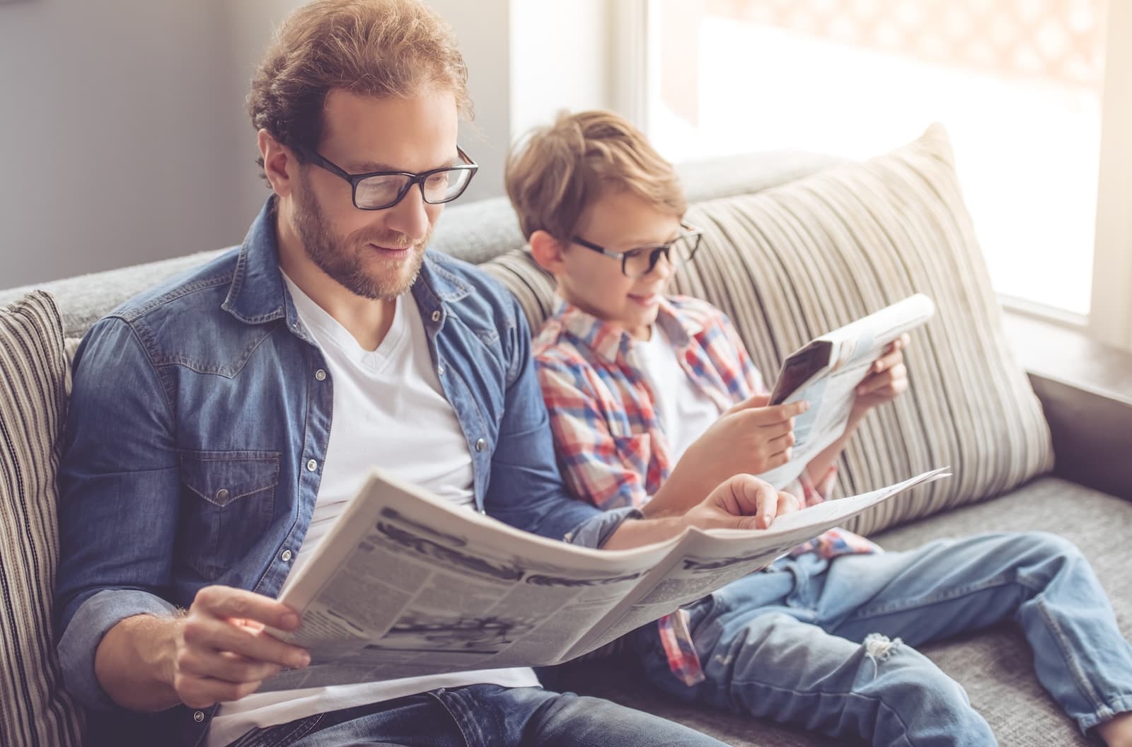 Man and child reading newspaper