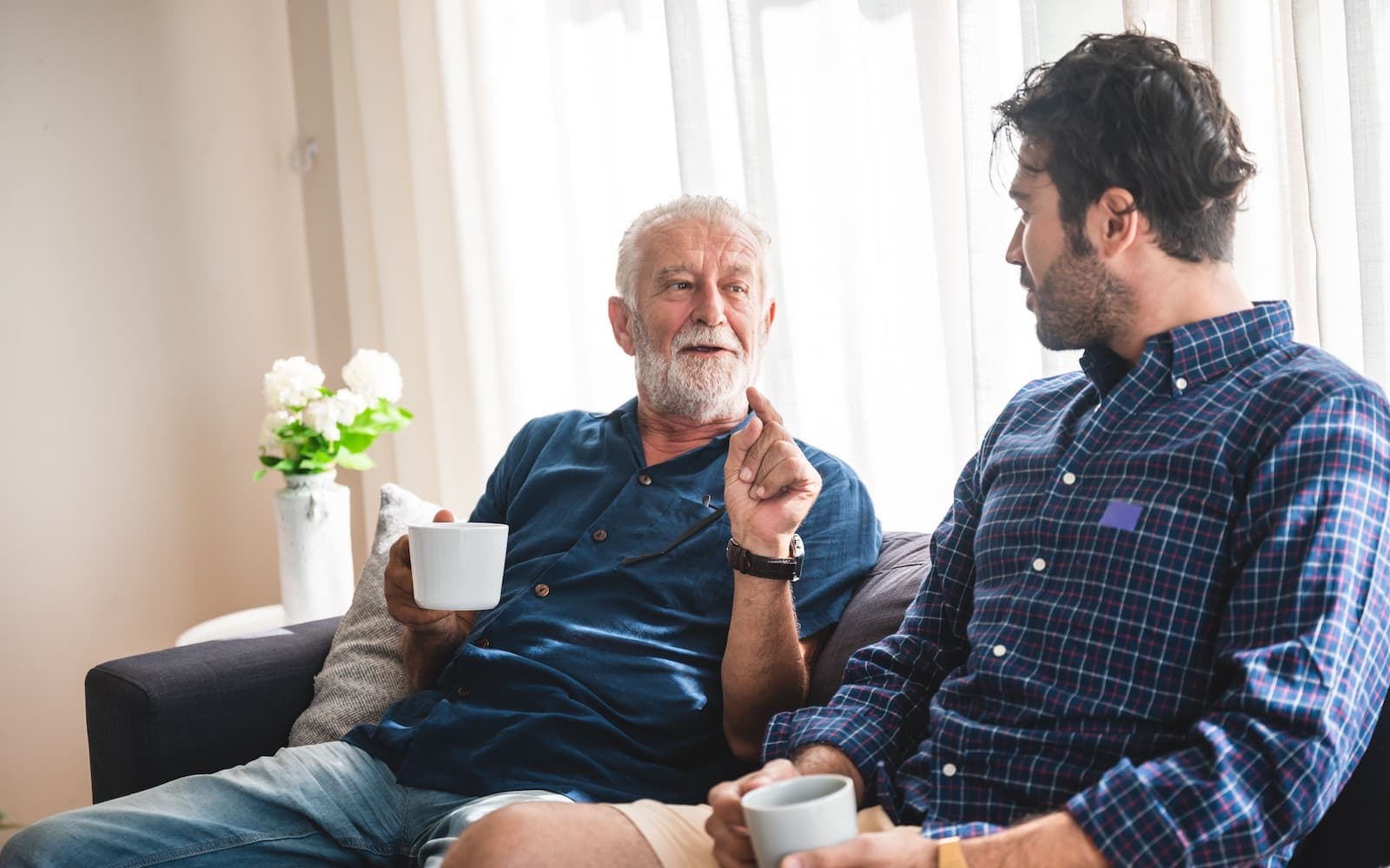 Elderly father and adult son talking in the house