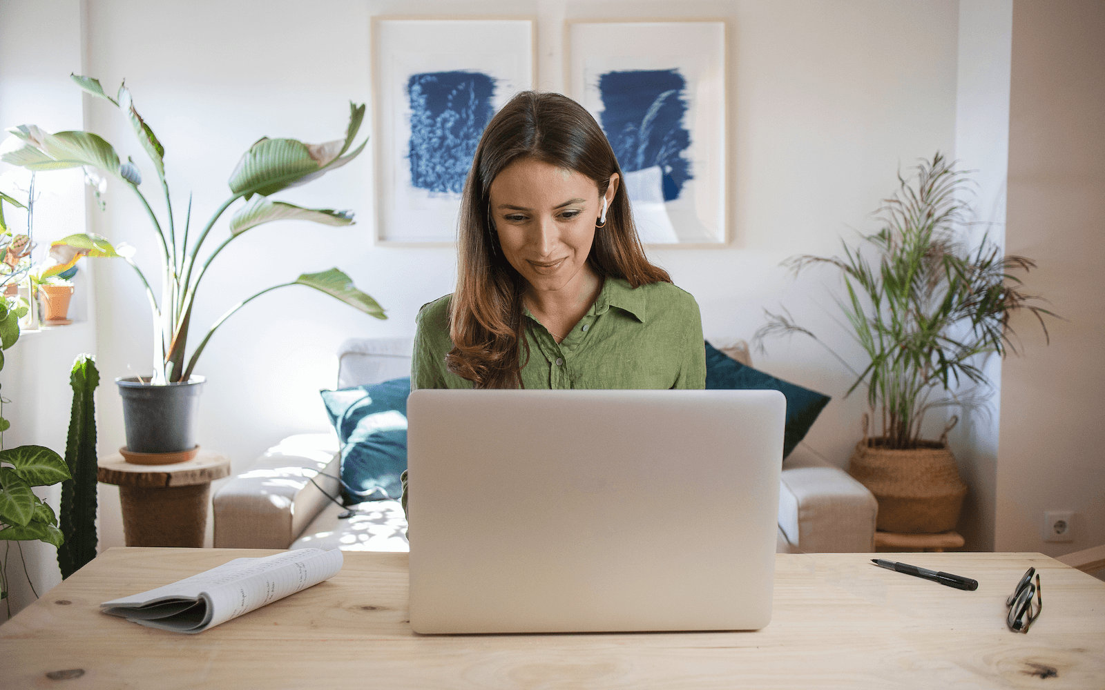 Woman sitting on a desk with laptop in a living space