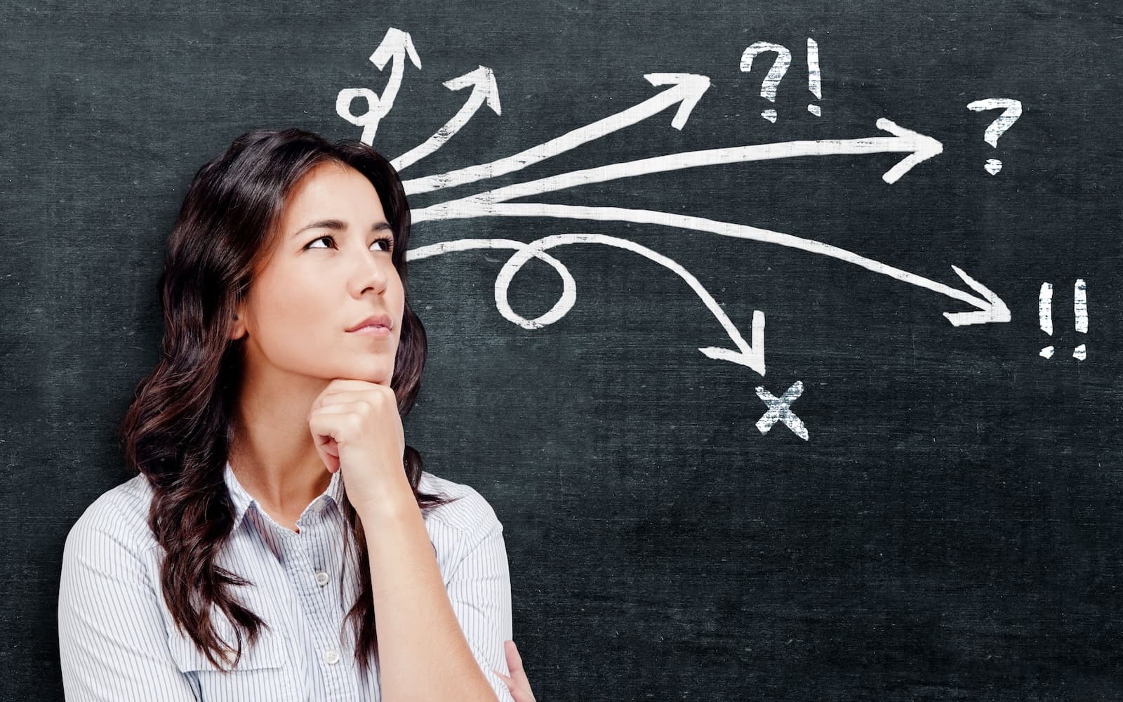 A lady standing in front of a blackboard thinking about financial decision
