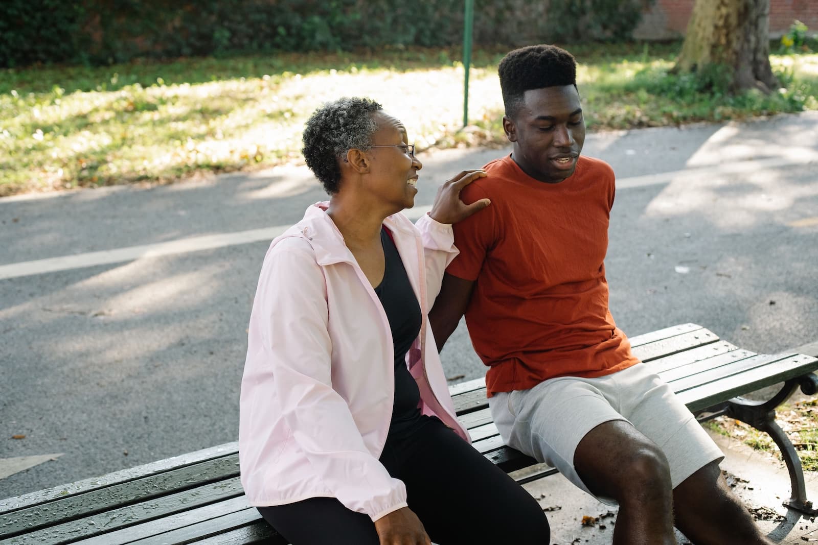 An aging woman and adult male sitting on a bench