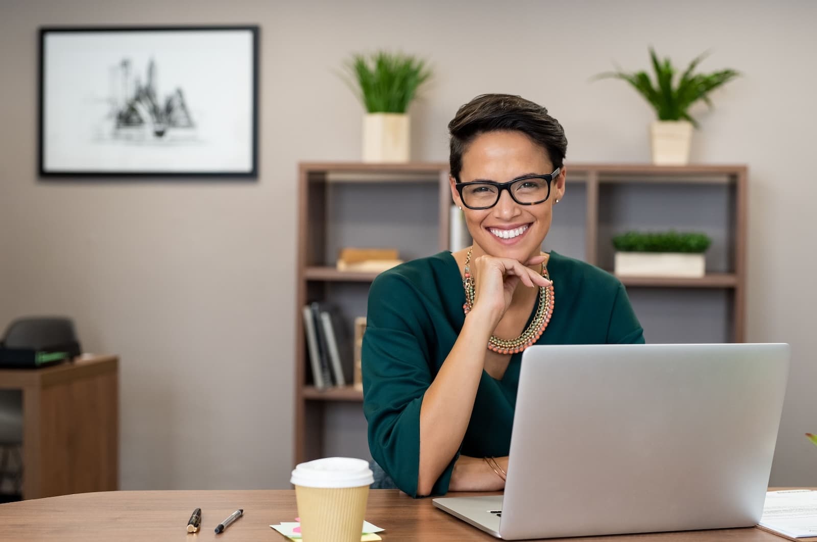 A smiling woman in front of a laptop