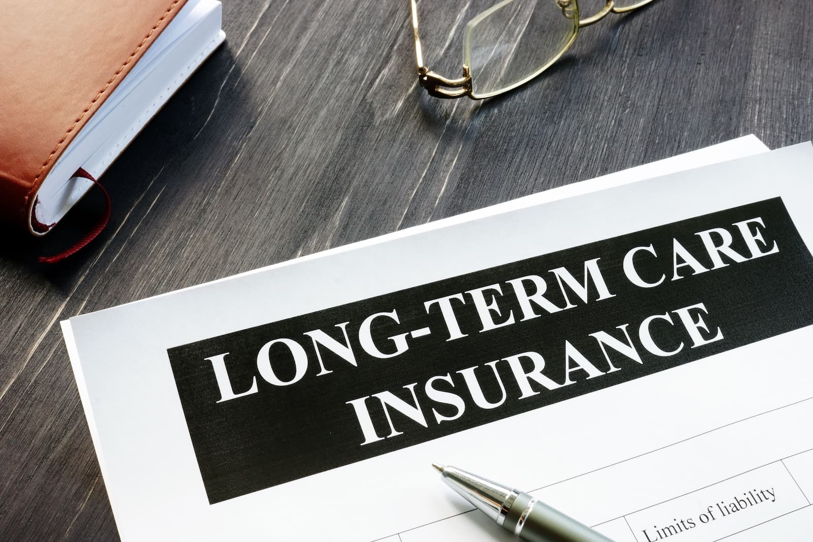 Notebook and long-term care insurance policy on a desk