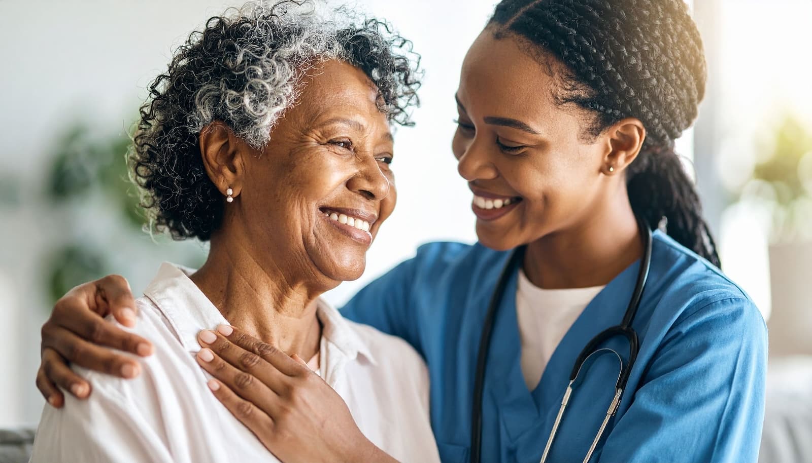 Friendly nurse supporting a senior woman patient